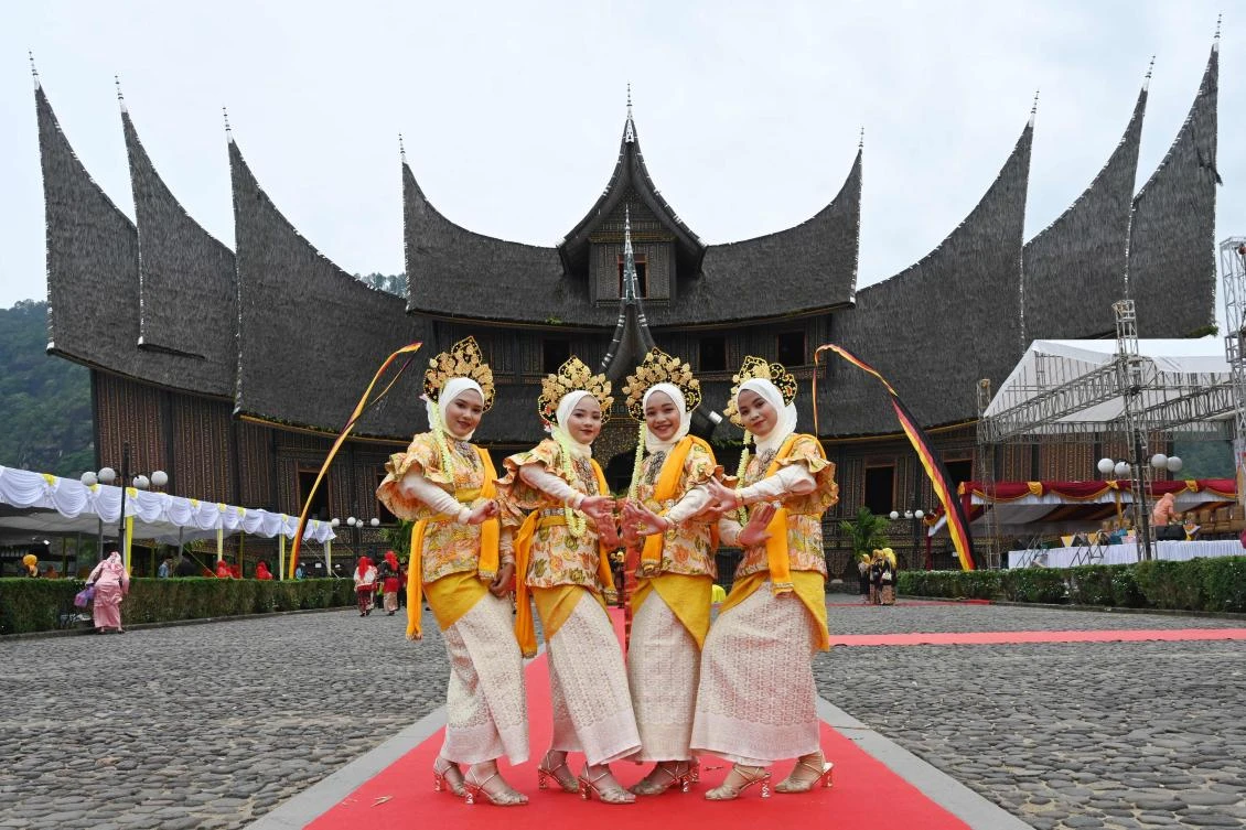 Indonesian dancers in Minangkabau traditional outfits participate at the 2018 Minangkabau art and culture festival in Batusangkar, West Sumatra with the Istano Basa Pagaruyuang at the background on November 28, 2018. The 2018 Minangkabau art and culture festival featuring variety of Minangkabau - one of Indonesia's ethnics - arts and culture that is held in Tanah Datar regency from November 28 - December 2 to boost both economy and tourism. / AFP / ADEK BERRY