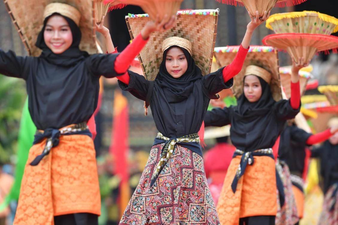 Indonesian dancers participate at the 2018 Minangkabau art and culture festival in Batusangkar, West Sumatra with the Istano Basa Pagaruyuang at the background on November 28, 2018. The 2018 Minangkabau art and culture festival featuring variety of Minangkabau - one of Indonesia's ethnics - arts and culture that is held in Tanah Datar regency from November 28 - December 2 to boost both economy and tourism. / AFP / ADEK BERRY