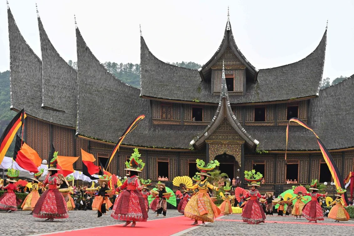 Indonesian dancers perform during the 2018 Minangkabau art and culture festival in Batusangkar, West Sumatra with the Istano Basa Pagaruyuang at the background on November 28, 2018. The 2018 Minangkabau art and culture festival featuring variety of Minangkabau - one of Indonesia's ethnics - arts and culture that is held in Tanah Datar regency from November 28 - December 2 to boost both economy and tourism. / AFP / ADEK BERRY
