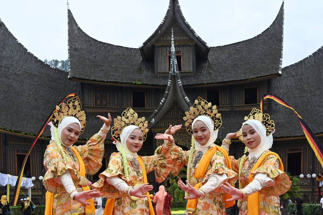 Indonesian dancers in Minangkabau traditional outfits participate at the 2018 Minangkabau art and culture festival in Batusangkar, West Sumatra with the Istano Basa Pagaruyuang at the background on November 28, 2018. The 2018 Minangkabau art and culture festival featuring variety of Minangkabau - one of Indonesia's ethnics - arts and culture that is held in Tanah Datar regency from November 28 - December 2 to boost both economy and tourism. / AFP / ADEK BERRY