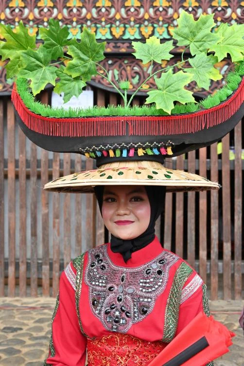 An Indonesian dancer waits for her turn to perform during the 2018 Minangkabau art and culture festival in Batusangkar, West Sumatra with the Istano Basa Pagaruyuang at the background on November 28, 2018. The 2018 Minangkabau art and culture festival featuring variety of Minangkabau - one of Indonesia's ethnics - arts and culture that is held in Tanah Datar regency from November 28 - December 2 to boost both economy and tourism. / AFP / ADEK BERRY