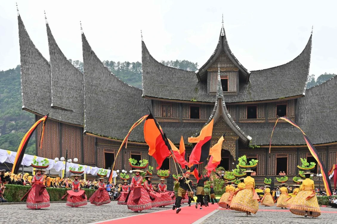Indonesian dancers perform during the 2018 Minangkabau art and culture festival in Batusangkar, West Sumatra with the Istano Basa Pagaruyuang at the background on November 28, 2018. The 2018 Minangkabau art and culture festival featuring variety of Minangkabau - one of Indonesia's ethnics - arts and culture that is held in Tanah Datar regency from November 28 - December 2 to boost both economy and tourism. / AFP / ADEK BERRY