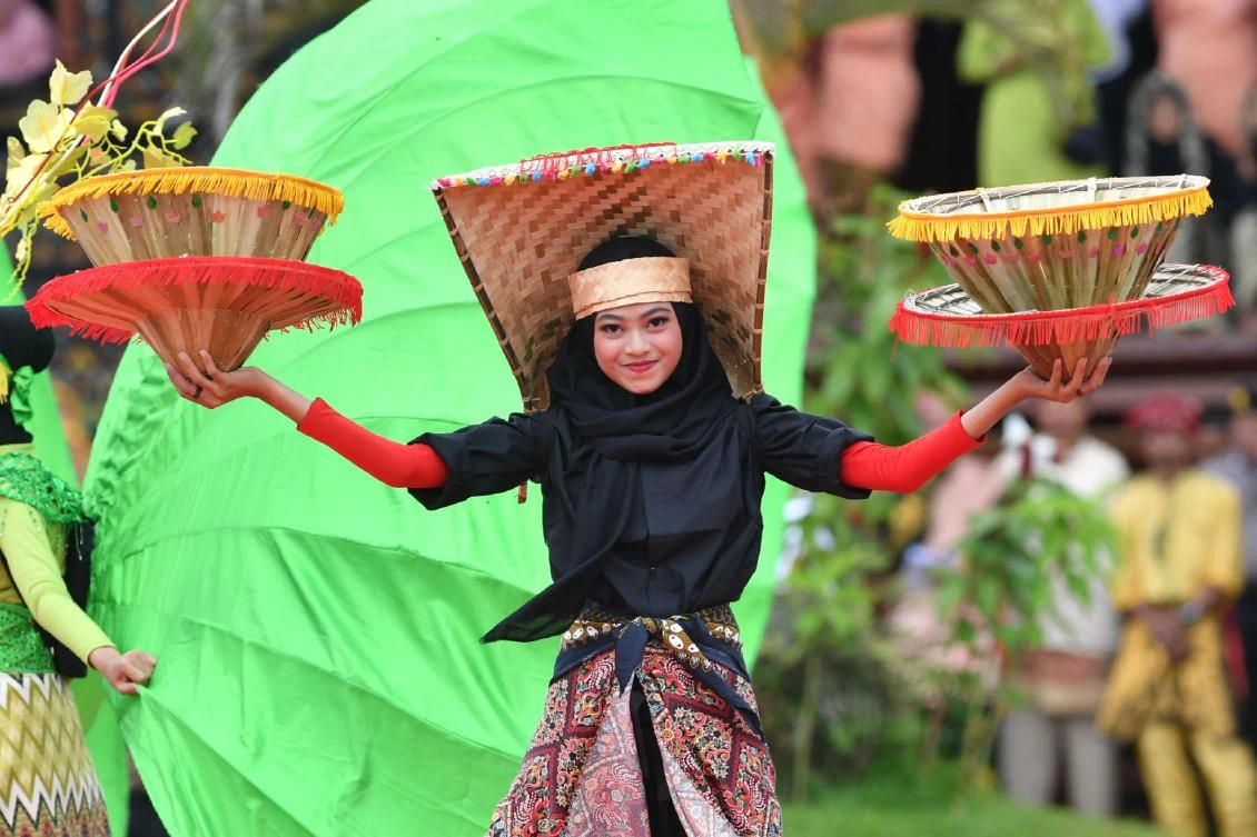 Indonesian dancers participate at the 2018 Minangkabau art and culture festival in Batusangkar, West Sumatra with the Istano Basa Pagaruyuang at the background on November 28, 2018. The 2018 Minangkabau art and culture festival featuring variety of Minangkabau - one of Indonesia's ethnics - arts and culture that is held in Tanah Datar regency from November 28 - December 2 to boost both economy and tourism. / AFP / ADEK BERRY