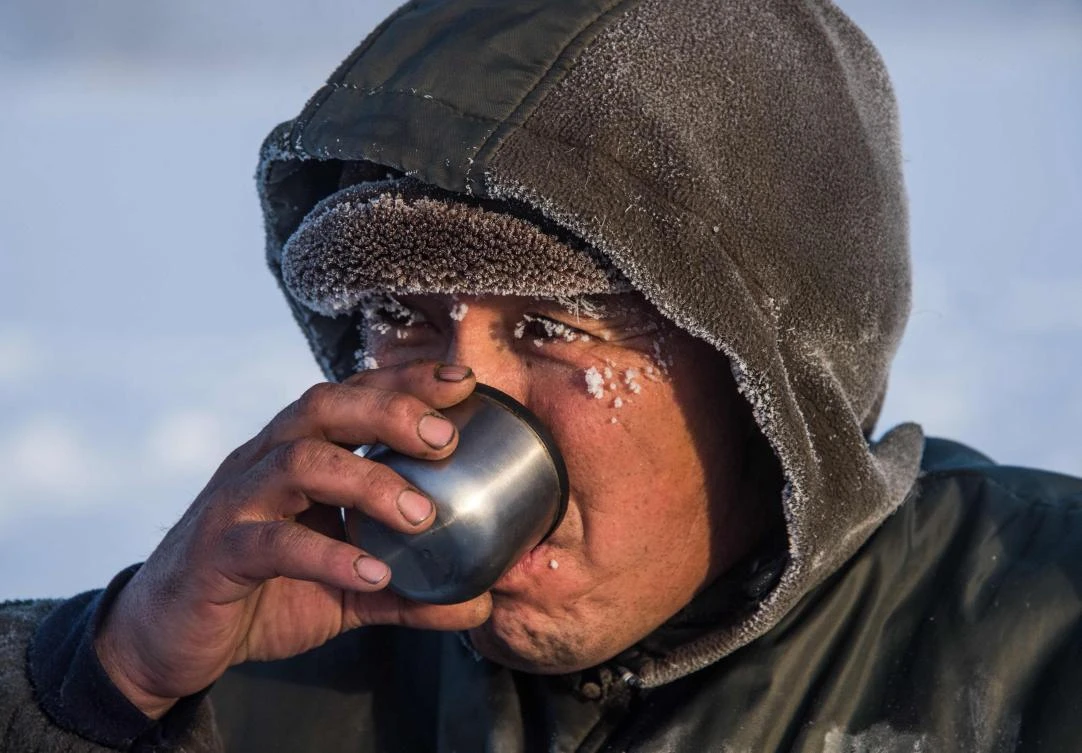 Villagers harvest ice from a local lake near the settlement of Oy, some 70 km south of Yakutsk, with the air temperature at about minus 41 degrees Celsius, on November 27, 2018. Many people in the Sakha (Yakutia) Republic depend on melted water as there is no other way to supply water due to extremely cold winter temperatures in the permafrost-covered region. / AFP / Mladen ANTONOV