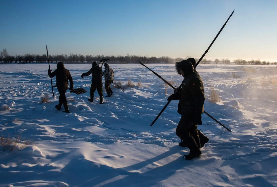 Villagers harvest ice from a local lake near the settlement of Oy, some 70 km south of Yakutsk, with the air temperature at about minus 41 degrees Celsius, on November 27, 2018. Many people in the Sakha (Yakutia) Republic depend on melted water as there is no other way to supply water due to extremely cold winter temperatures in the permafrost-covered region. / AFP / Mladen ANTONOV
