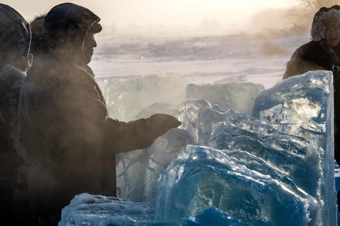 Villagers harvest ice from a local lake near the settlement of Oy, some 70 km south of Yakutsk, with the air temperature at about minus 41 degrees Celsius, on November 27, 2018. Many people in the Sakha (Yakutia) Republic depend on melted water as there is no other way to supply water due to extremely cold winter temperatures in the permafrost-covered region. / AFP / Mladen ANTONOV