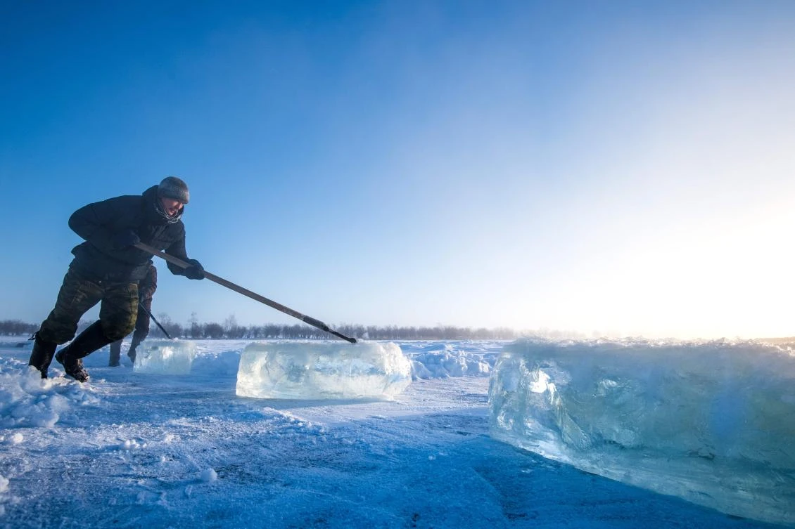 Villagers harvest ice from a local lake near the settlement of Oy, some 70 km south of Yakutsk, with the air temperature at about minus 41 degrees Celsius, on November 27, 2018. Many people in the Sakha (Yakutia) Republic depend on melted water as there is no other way to supply water due to extremely cold winter temperatures in the permafrost-covered region. / AFP / Mladen ANTONOV