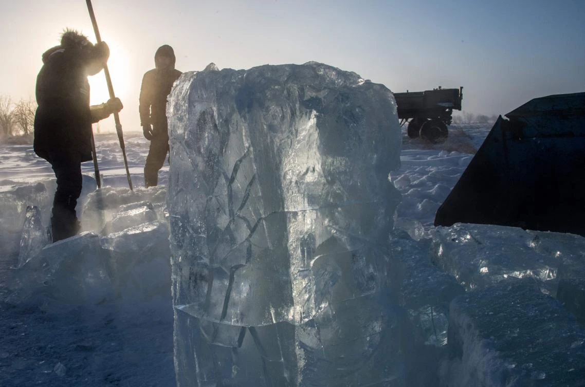 Villagers harvest ice from a local lake near the settlement of Oy, some 70 km south of Yakutsk, with the air temperature at about minus 41 degrees Celsius, on November 27, 2018. Many people in the Sakha (Yakutia) Republic depend on melted water as there is no other way to supply water due to extremely cold winter temperatures in the permafrost-covered region. / AFP / Mladen ANTONOV
