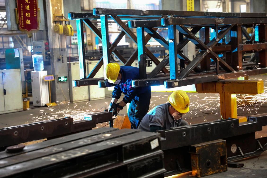 China’s economy grew at its slowest pace in nine years in the third quarter as trade frictions with the US had an effect. Above, welders at a truck manufacturer in Weihai. (AFP)