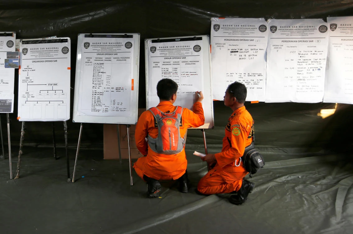 Indonesian rescue team members write the progress of the recovery process for Lion Air flight JT610. (Reuters)