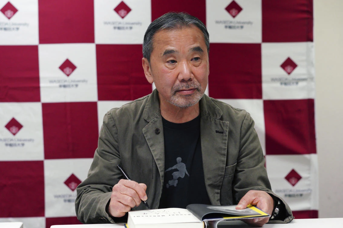 Japanese novelist Haruki Murakami signs his autograph on his novel ‘Killing Commendatore’ during a press conference at Waseda University in Tokyo on Saturday, Nov. 3. (AP)