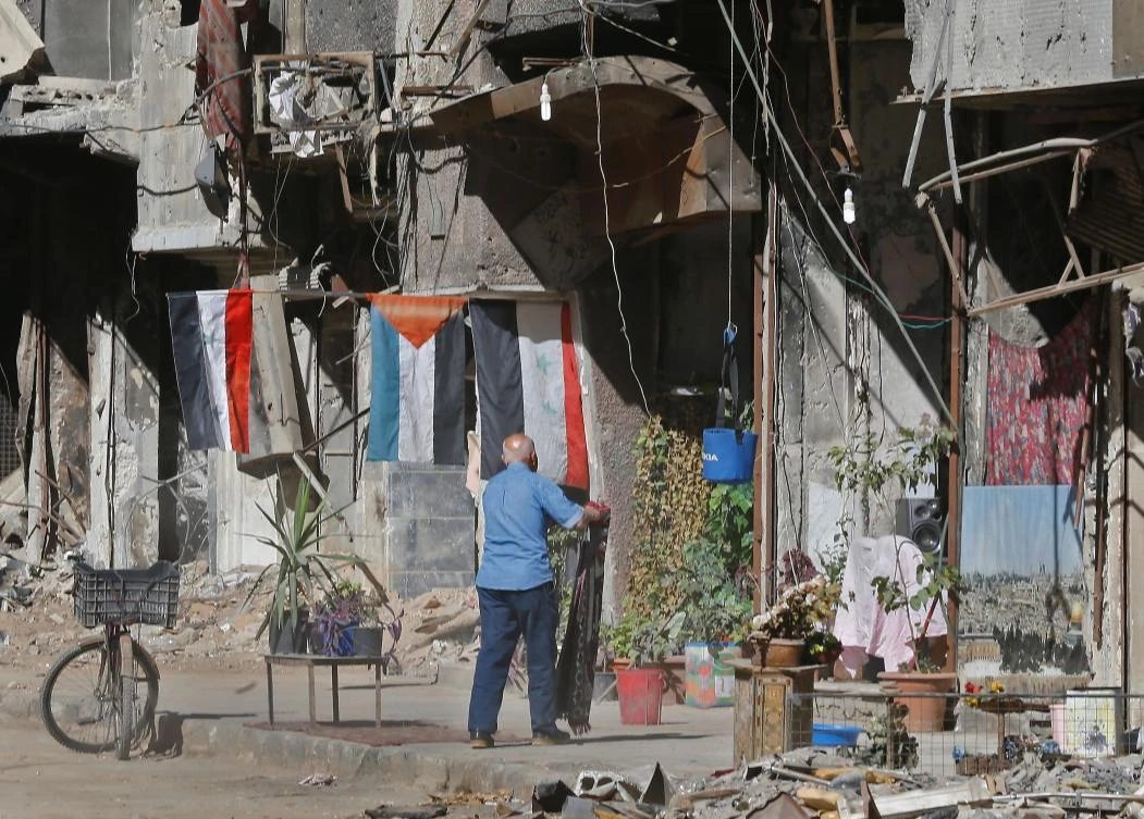 A man stands in a street near destroyed buildings in the Palestinian camp of Yarmuk southern Damascus on November 1, 2018. (AFP)