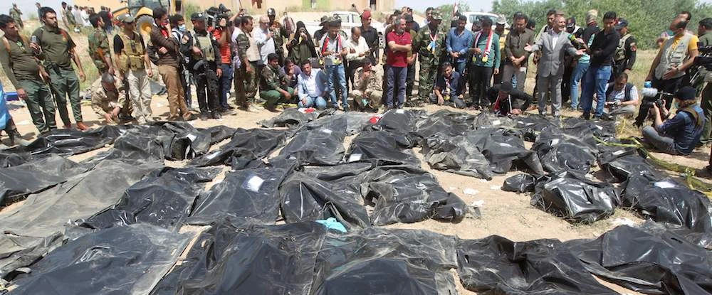 Iraqis mourn near body-bags containing the remains of people killed by Daesh in the Iraqi city of Tikrit. (AFP)