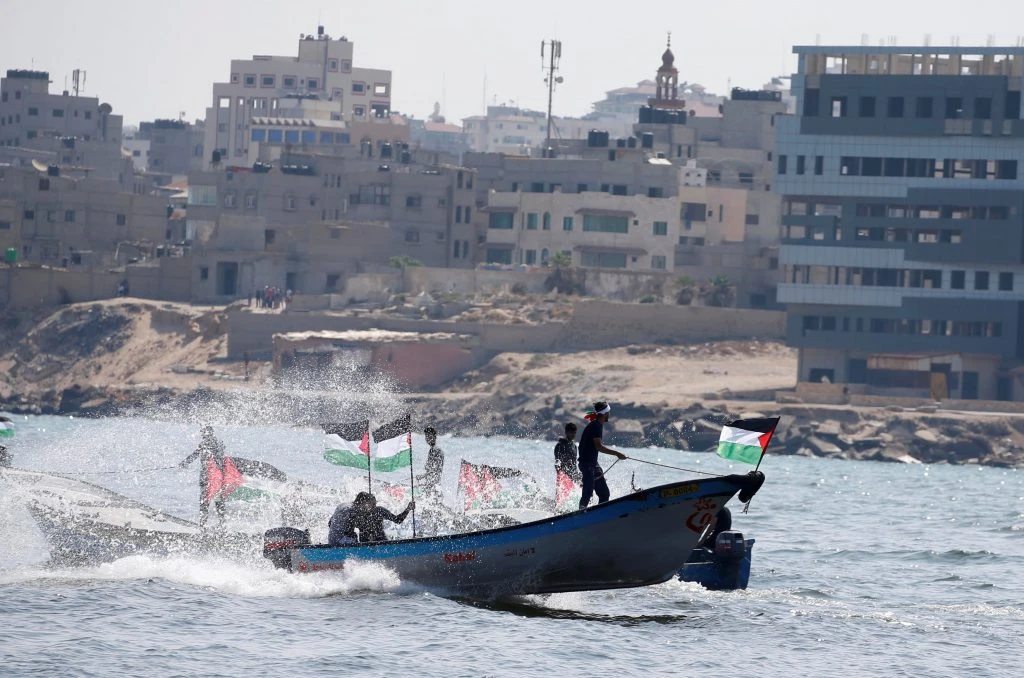 People ride boats as Palestinians prepare to sail a ship toward Europe aiming to break Israel's maritime blockade on Gaza, Tuesday. (Reuters)