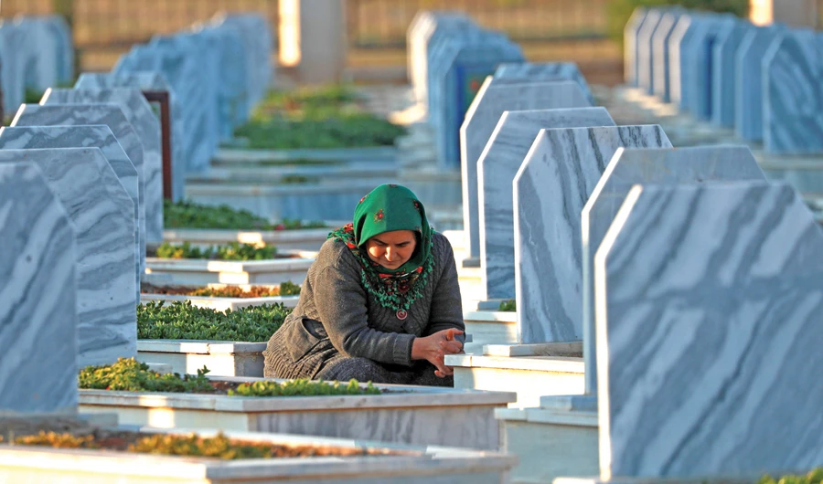 A woman visits the grave of an SDF fighter, killed in a Daesh attack near Deir Ezzor, Syria, on Wednesday. (AFP)