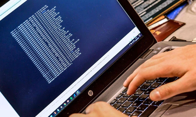 In this file photo taken on January 23, 2018 a person works at a computer during the 10th International Cybersecurity Forum in Lille, France. (AFP)