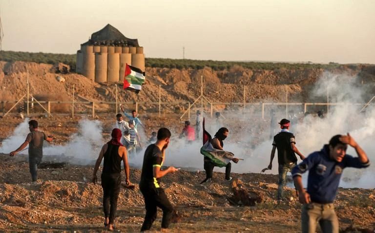 Palestinian protesters react to tear gas fired by Israeli forces during clashes in east of Gaza City near the Israeli border on November 2, 2018. (AFP)