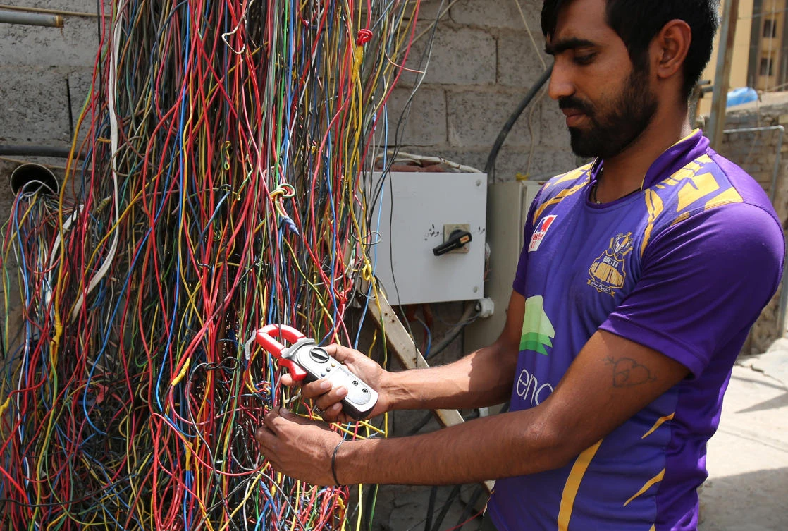 An Iraqi man checks the wiring of an electric generator supplying homes with electricity in Baghdad. (AFP)