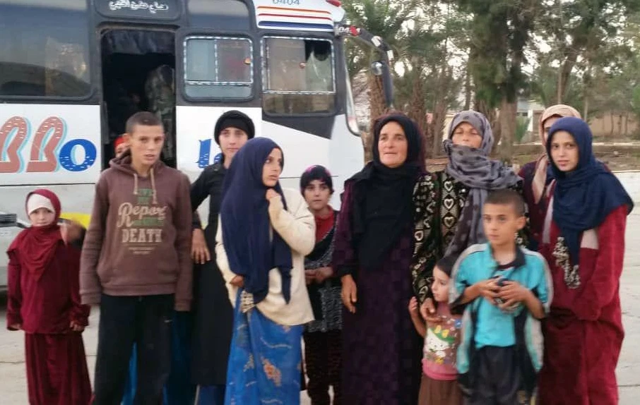 A handout picture released by the official Syrian Arab News Agency (SANA) on November 8, 2018 shows a group of Druze women and children, abducted in July from the southern province of Sweida by Daesh, standing in front of a bus upon being freed at an undisclosed location. (AFP / SANA)
