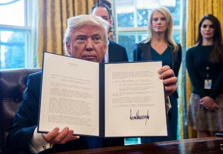 US President Donald Trump shows an executive order on January 24, 2017 reviving the construction of two controversial oil pipelines – the Keystone XL pipeline and an equally controversial pipeline crossing in North Dakota. (AFP)