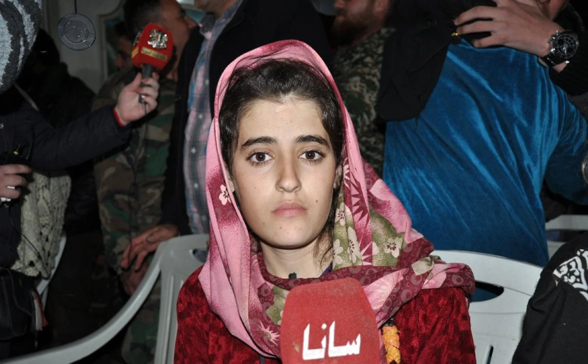 A handout picture released by SANA on November 9, 2018 shows one of a group of Druze women, who were abducted in July from Sweida by Daesh, talking to the media upon their arrival overnight in their hometown in Sweida. (AFP / SANA)