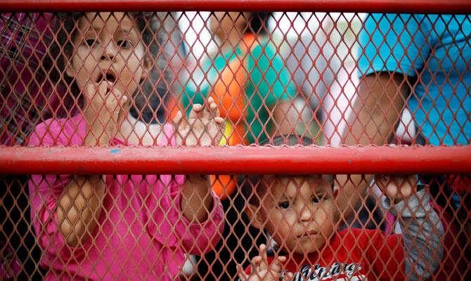 Migrants children, part of a caravan traveling from Central America en route to the United States, look from a truck after resting with others in a makeshift camp in Matias Romero, Mexico, November 9, 2018. (REUTERS)