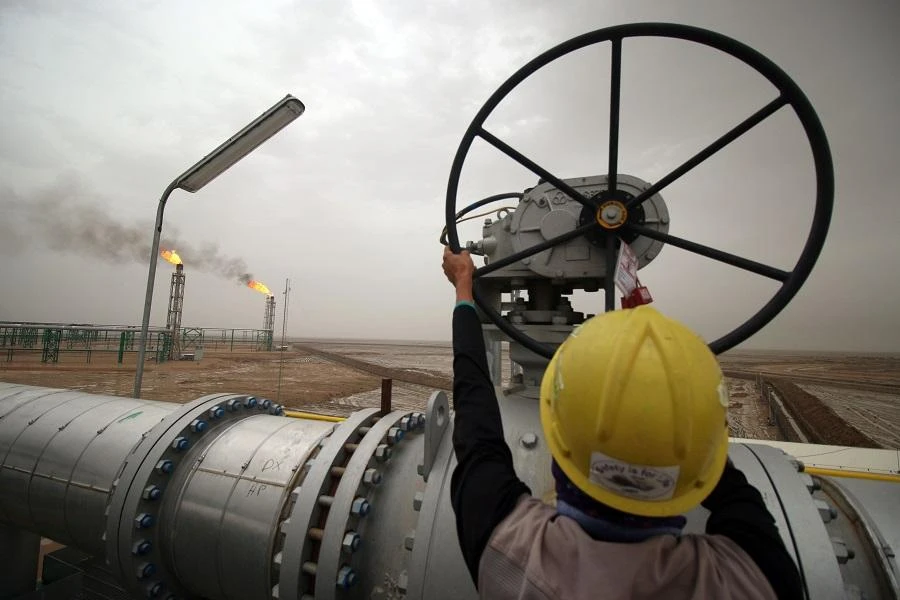 An employee turns a valve at the Hammar Mushrif new Degassing Station Facilities site inside the Zubair oil and gas field, north of the southern Iraqi province of Basra. (File/AFP)