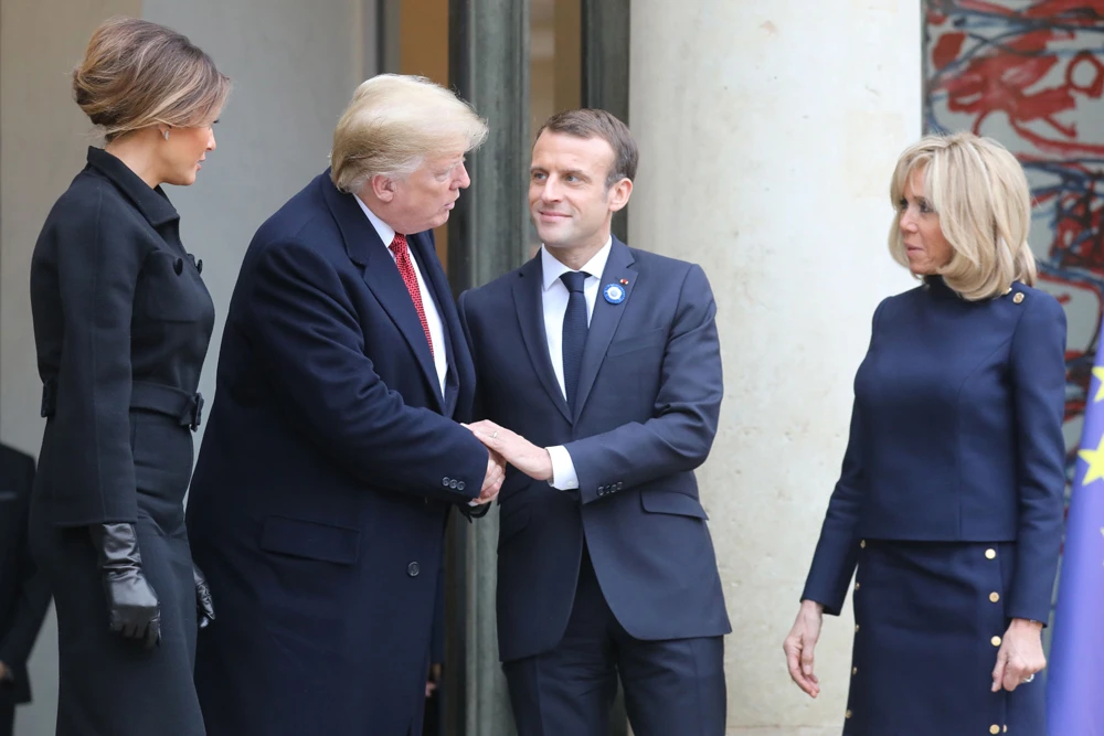 US President Donald Trump addresses French first lady Brigitte Macron as he shakes hands with President Emmanuel Macron at the Elysee Palace in Paris on Saturday following bilateral talks. (AFP)
