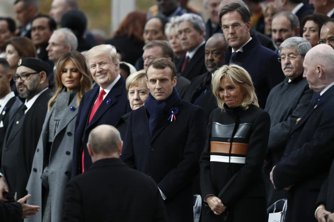 Russian President Vladimir Putin, back to camera, arrives to take his seat with French President Emmanuel Macron, Brigitte Macron, German Chancellor Angela Merkel, US President Donald Trump and first lady Melania Trump to attend a commemoration ceremony for Armistice Day, 100 years after the end of the First World War at the Arc de Triomphe in Paris, France, Nov. 11, 2018. (Benoit Tessier/Pool Photo via AP)