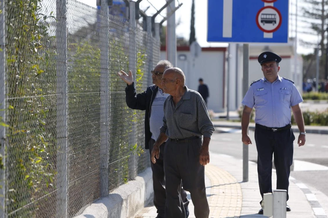 People look at unoccupied houses at the site of the newly-opened Dherynia crossing separating the Republic of Cyprus and the self-proclaimed Turkish Republic of Northern Cyprus. (AFP)