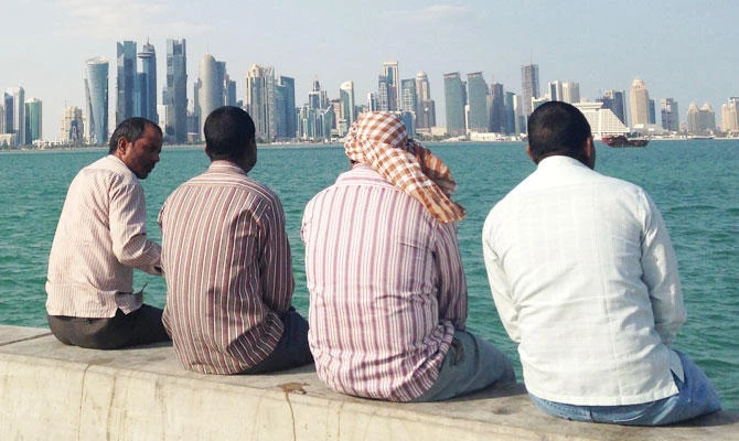 In this Nov. 7, 2014, file photo, men talk by the sea overlooking the Qatar skyline in Doha, Qatar. (AP)