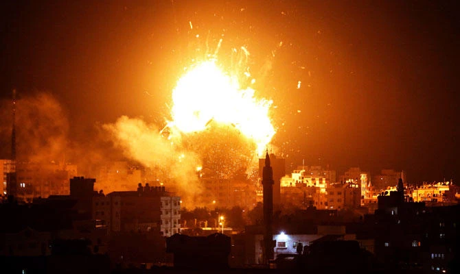 A photo taken on November 12, 2018 shows a ball of fire above the building housing the Hamas-run television station al-Aqsa TV in Gaza City during an Israeli air strike. (AFP)