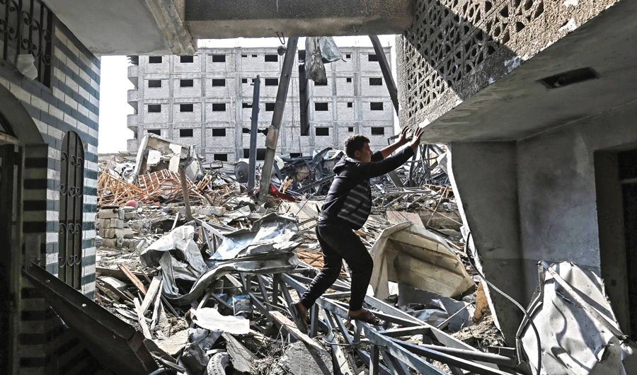 A Palestinian stands amid the rubble of the building housing the Hamas-run television station Al-Aqsa TV, destroyed by an Israeli airstrike. (AFP )