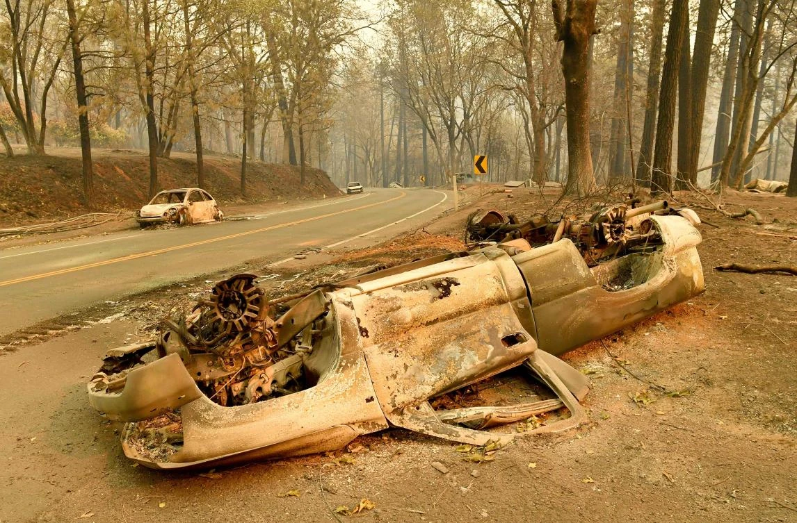 Burned cars litter a road during the Camp fire in Paradise, California on November 12, 2018. (FP)