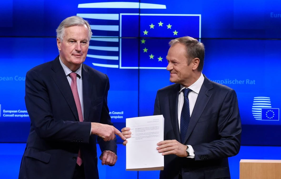 EU Brexit chief negotiator Michel Barnier, left, hands over to European Council President Donald Tusk the draft Brexit agreement on Thursday, November 15. (AFP)