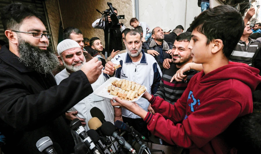 Palestinians celebrate the resignation of Israel's defense minister. (AFP)