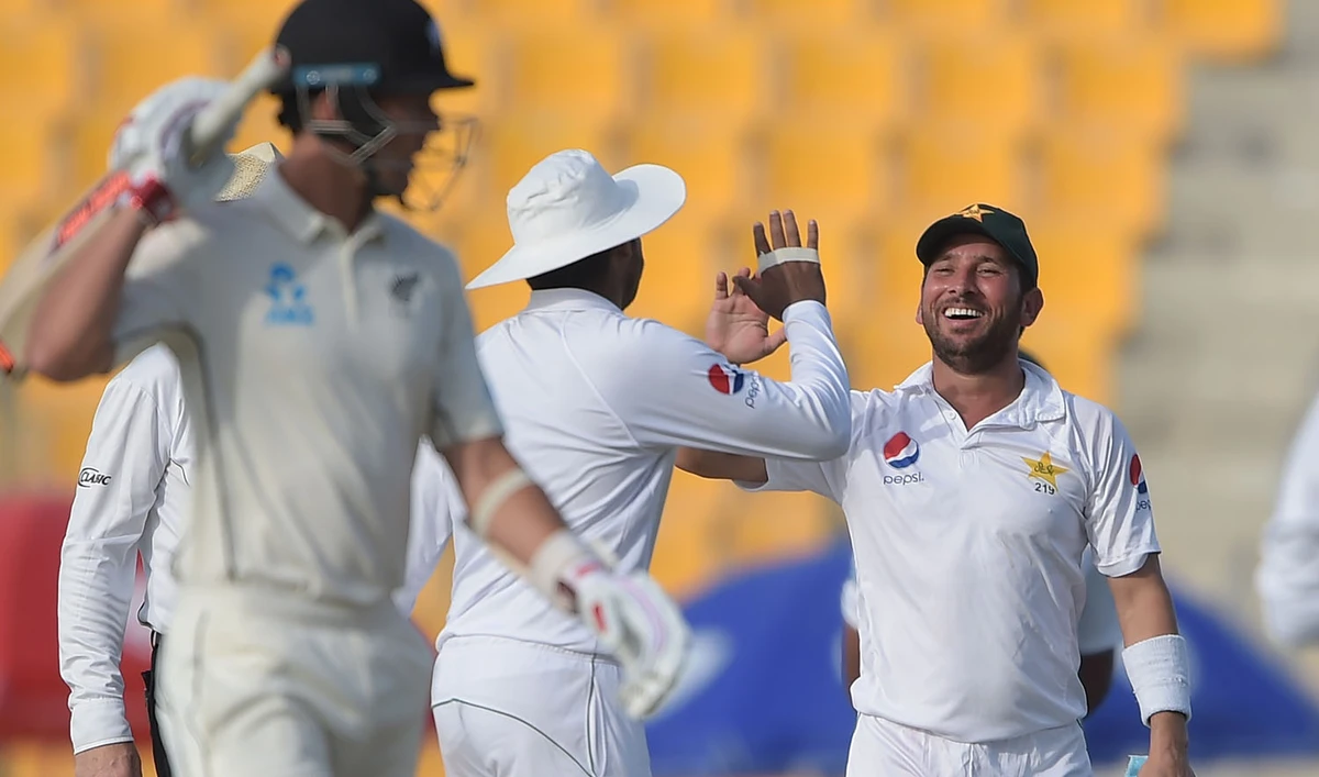 Pakistani spinner Yasir Shah, right, celebrates with his teammate after taking the wicket of New Zealand batsman Ajaz Patel during the first Test match between Pakistan and New Zealand at the Sheikh Zayed International Cricket Stadium in Abu Dhabi on Nov. 16, 2018. (AFP)