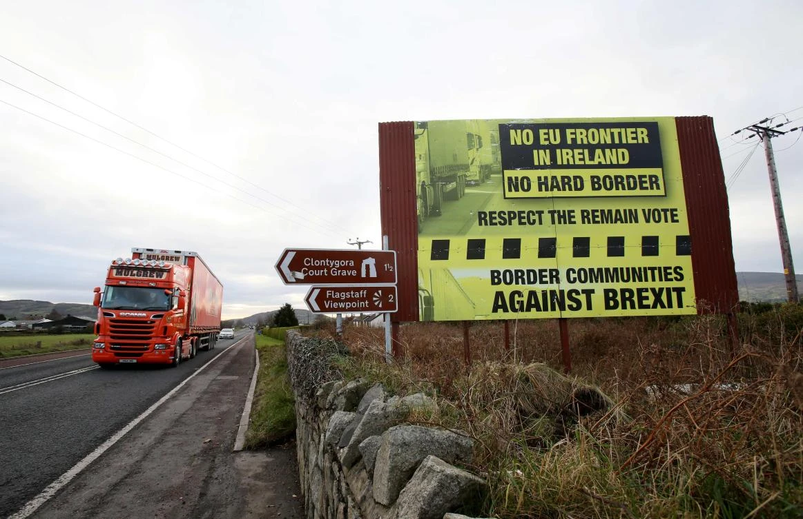 Traffic crosses the border into Northern Ireland from the Irish Republic alongside a Brexit poster on the road between Dundalk in the Irish Republic and Newry in Northern Ireland. (AFP)