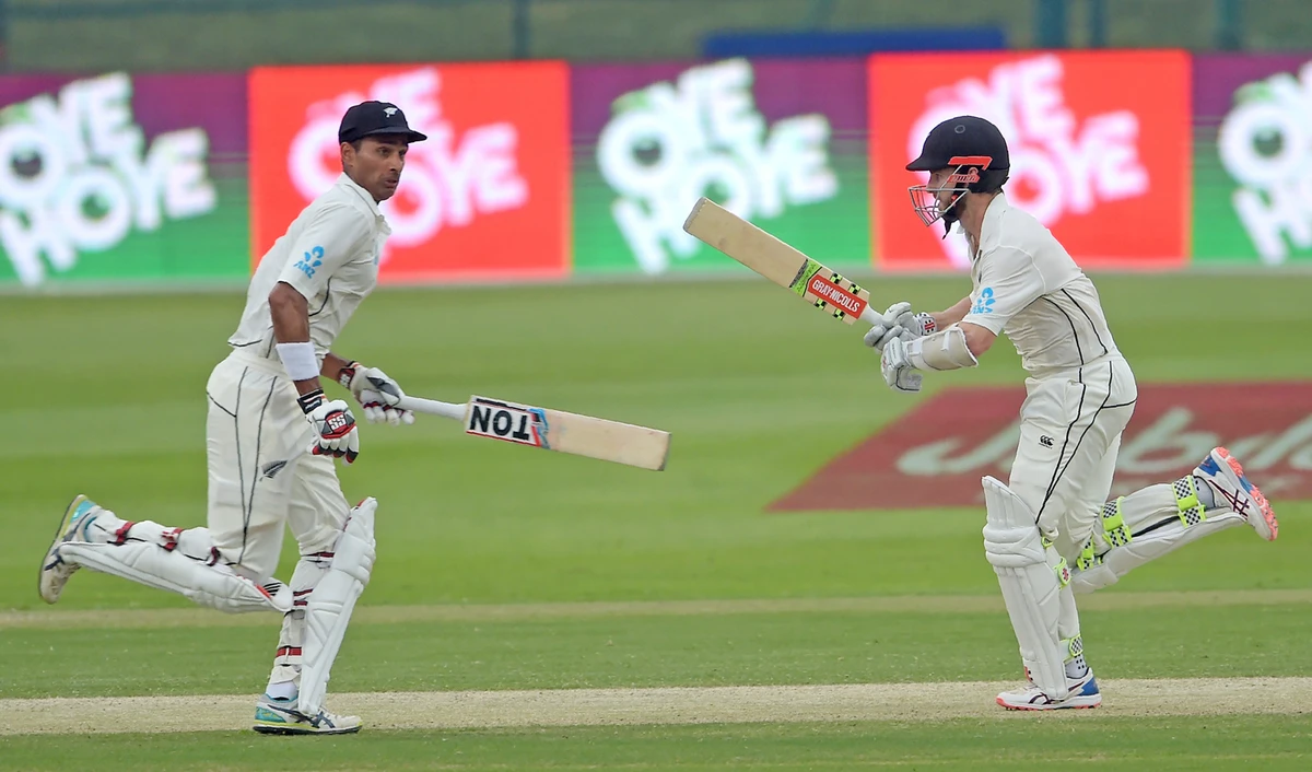 New Zealand captain Kane Williamson (R) and teammate Jeet Raval run between the wicket during the second day of the first Test cricket match between Pakistan and New Zealand at the Sheikh Zayed International Cricket Stadium in Abu Dhabi on Nov. 17, 2018. (AFP)