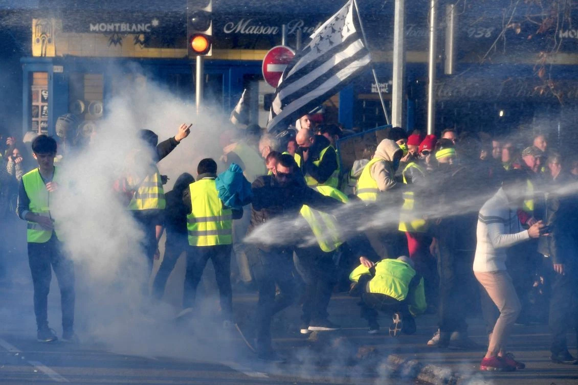 Demonstrators receive tear gas on November 17, 2018 in Quimper, western France, during a nationwide popular initiated day of protest called “yellow vest” (Gilets Jaunes in French) movement to protest against high fuel prices. (AFP)