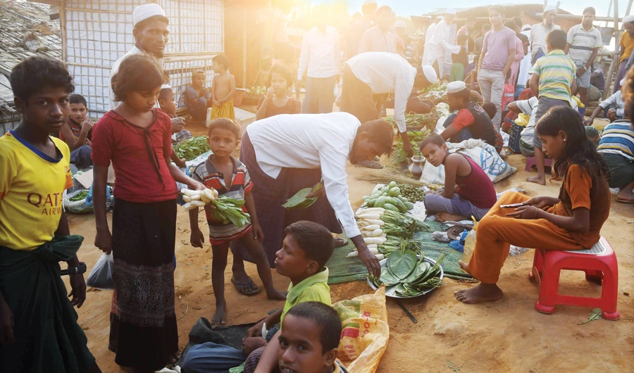 Rohingya refugees at a market at the Hakimpara refugee camp on Sunday. (AFP)