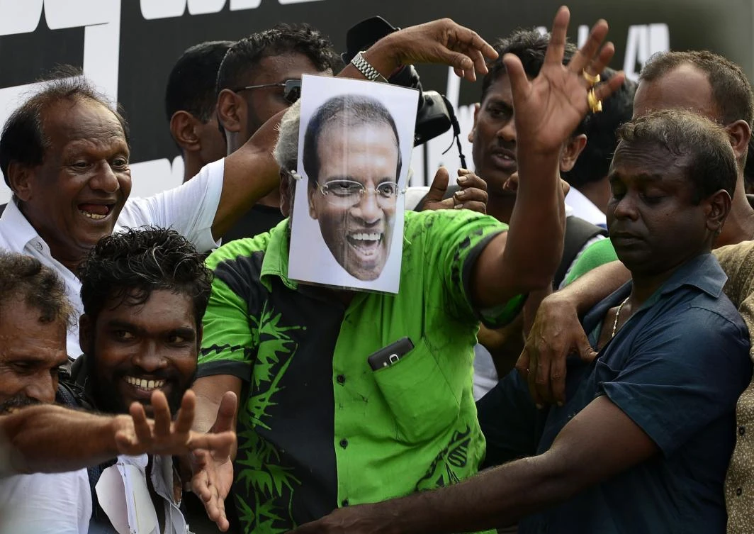 A protester wears a mask depicting Sri Lankan President Maithripala Sirisena during a rally in Colombo on November 15. (AFP)