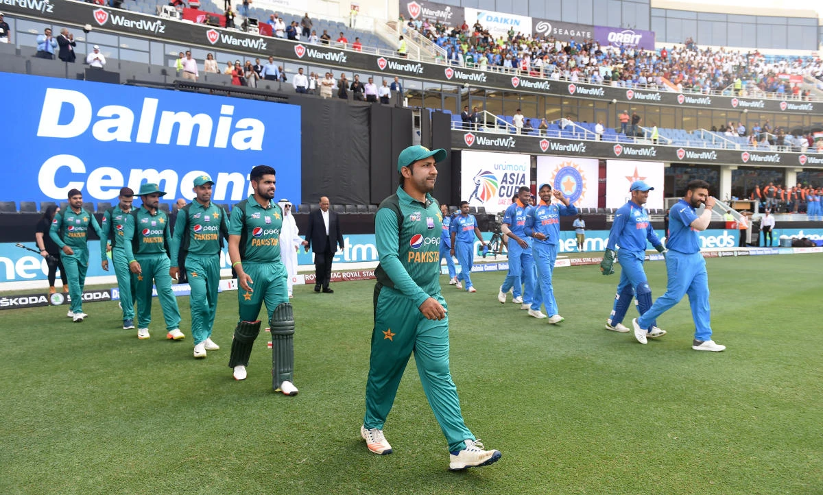 A rare sight in cricket these days — Pakistan and India teams walking out onto the same pitch. (AFP)