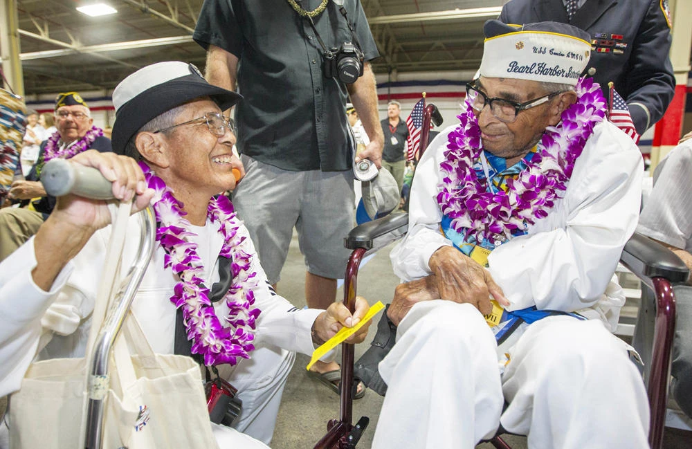 In this Dec. 7, 2016, file photo, Kathleen Chavez, left, talks with her father Ray Chavez, right, age 104, of the USS Condor, the oldest living survivor from the Pearl Harbor attacks at a gathering of World War II survivors at the Pacific National Monument in Honolulu. (AP Photo/Eugene Tanner, File)