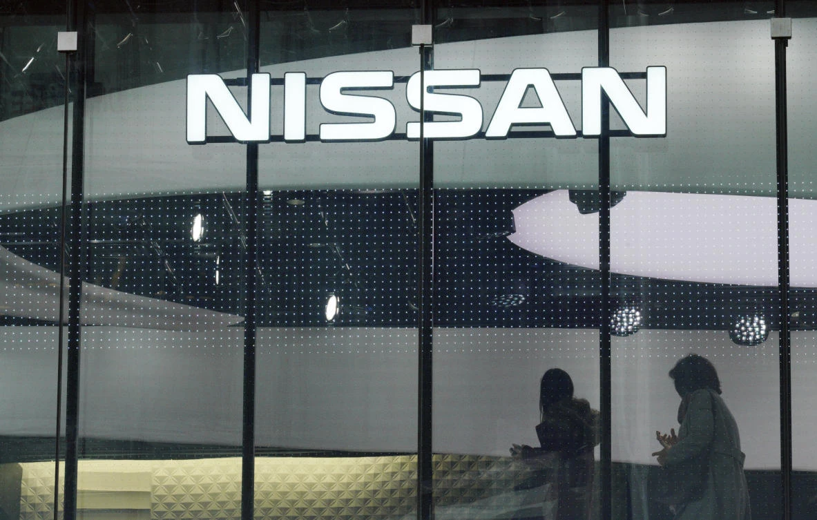 Visitors walk near the logo of Nissan at a Nissan showroom in Tokyo Thursday, Nov. 22, 2018. (AP)