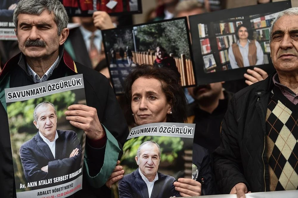 Protesters hold poster portraits of Cumhuriyet's chairman Akin Atalayas they attend a demonstration at the courthouse in Istanbul on March 15, 2018. (File/AFP)