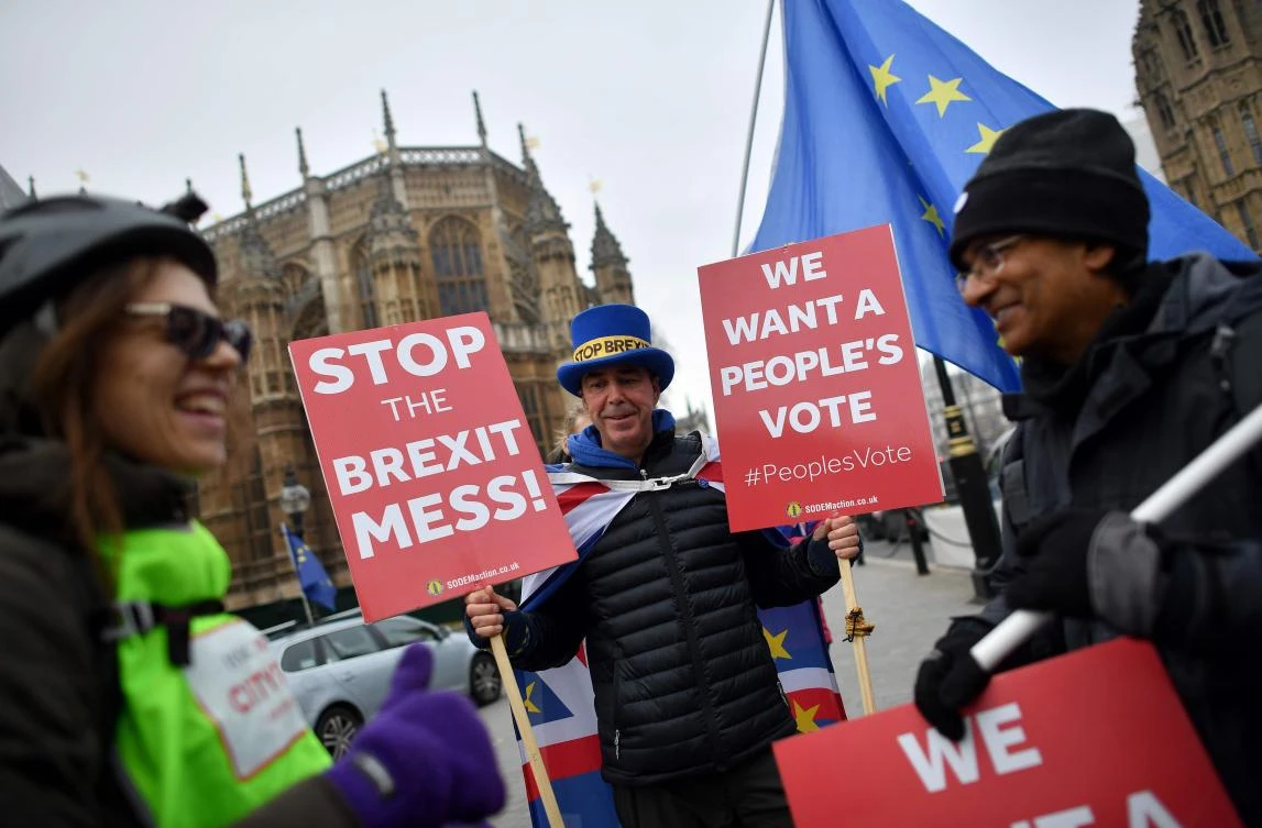 Anti-Brexit demonstrators hold placards calling for a “People’s Vote” as they protest outside the Houses of Parliament in central London. (AFP)