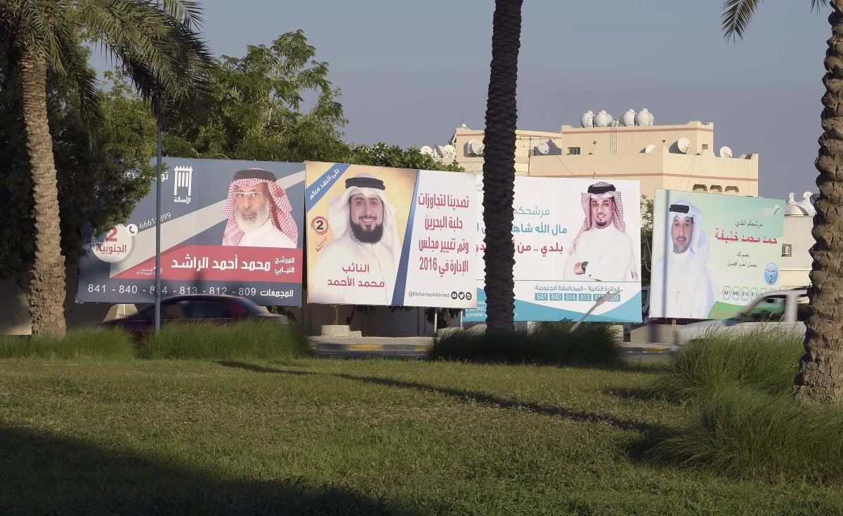 Billboards carrying pictures of candidates running for Bahrain’s legislative elections are seen on the streets of Isa Town south of Manama on Nov. 22. (AFP)