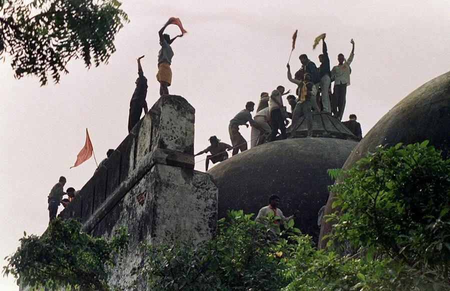 In this file photograph taken on Dec. 6, 1992 Hindu youths clamor atop the 16th century Muslim Babri Mosque five hours before the structure was completely demolished by hundreds supporting Hindu fundamentalist activists. (File/AFP/Douglas E Curran)