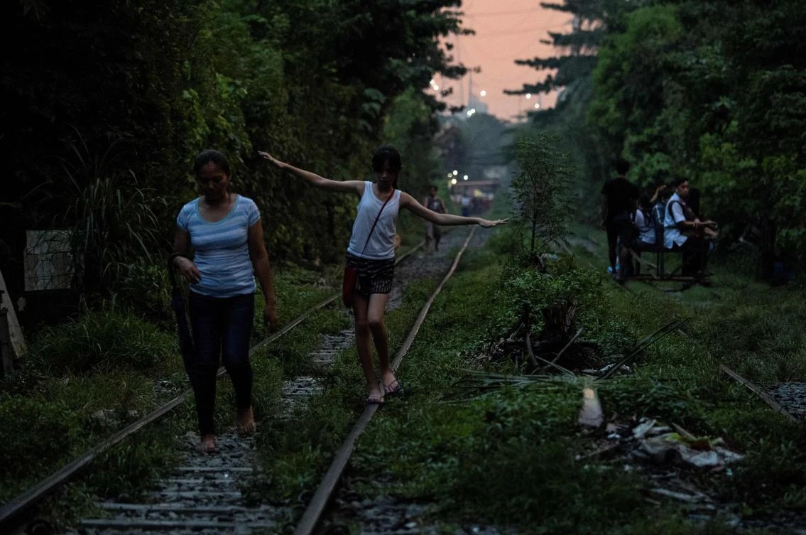 Scores of commuters in the city of about 12 million are propelled to their destinations daily by so-called “trolley boys.” (AFP/Noel Celis)